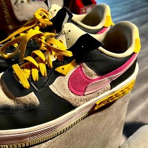 Nike shoes with hot pink swoosh. The colors yellow pink black and beige.